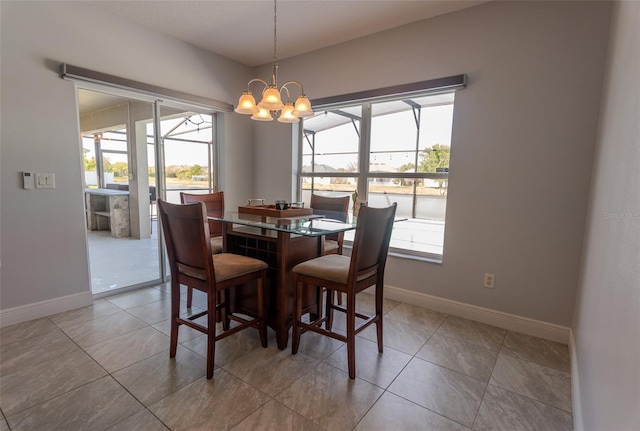 dining room with light tile patterned floors, an inviting chandelier, and baseboards