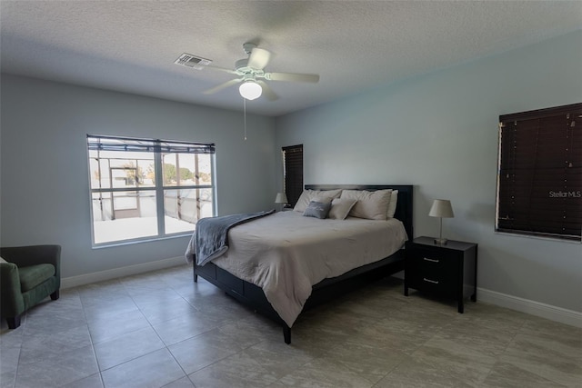 bedroom with baseboards, visible vents, and a textured ceiling