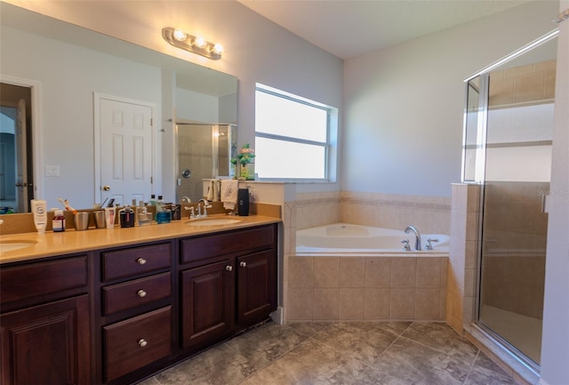 bathroom with a bath, a shower stall, double vanity, and a sink