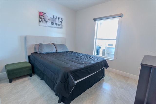 bedroom featuring light tile patterned floors and baseboards