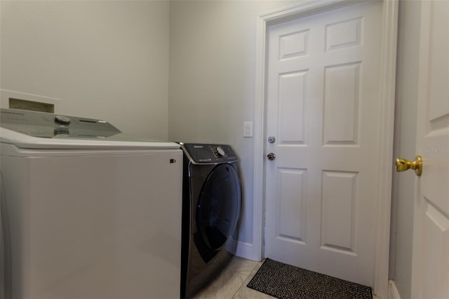 clothes washing area with light tile patterned floors, laundry area, and washer and dryer