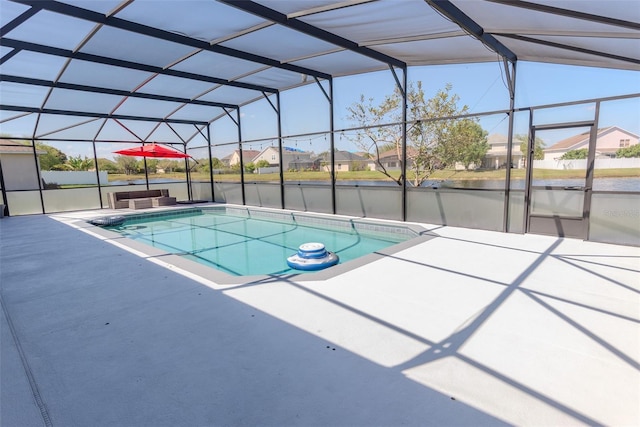 outdoor pool featuring glass enclosure, a residential view, and a patio area