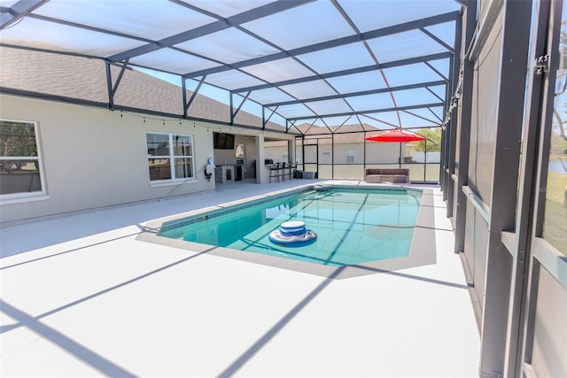 pool with glass enclosure and a patio area