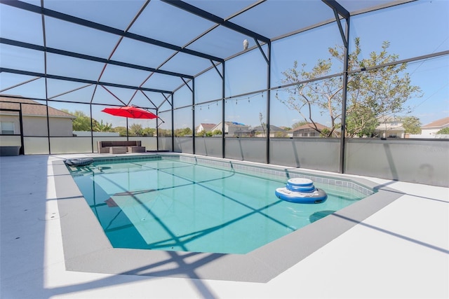 pool with glass enclosure and a patio area