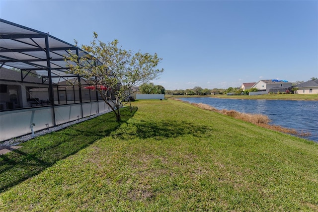 view of yard featuring glass enclosure and a water view