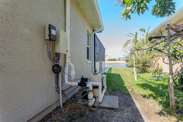 view of side of property featuring stucco siding and a lawn