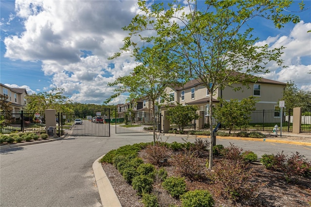 4409 Summer Flowers Pl, Kissimmee, FL 34746 - view of road featuring a gate, curbs, a residential view, and a gated entry