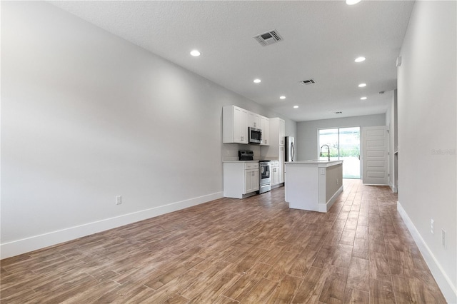 4409 Summer Flowers Pl, Kissimmee, FL 34746 - unfurnished living room featuring visible vents, baseboards, and light wood-style flooring