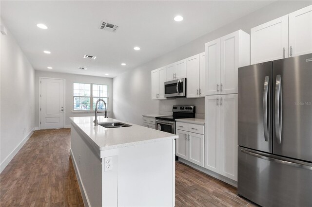 4409 Summer Flowers Pl, Kissimmee, FL 34746 - kitchen with visible vents, dark wood finished floors, a kitchen island with sink, a sink, and appliances with stainless steel finishes