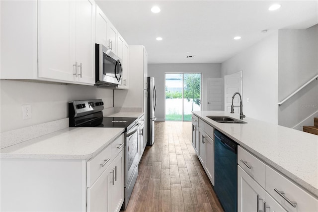 4409 Summer Flowers Pl, Kissimmee, FL 34746 - kitchen with recessed lighting, appliances with stainless steel finishes, wood finished floors, white cabinetry, and a sink