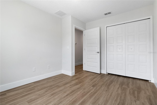 4409 Summer Flowers Pl, Kissimmee, FL 34746 - unfurnished bedroom featuring visible vents, a textured ceiling, wood finished floors, a closet, and baseboards