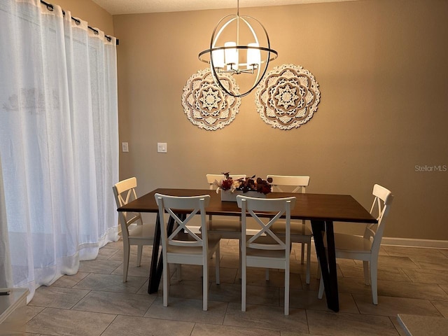 dining space featuring a notable chandelier and baseboards