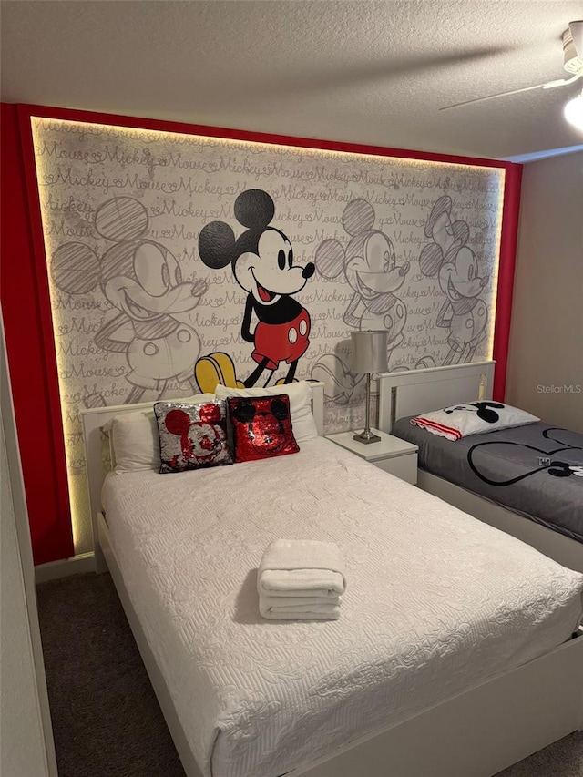 bedroom with a ceiling fan, carpet, and a textured ceiling