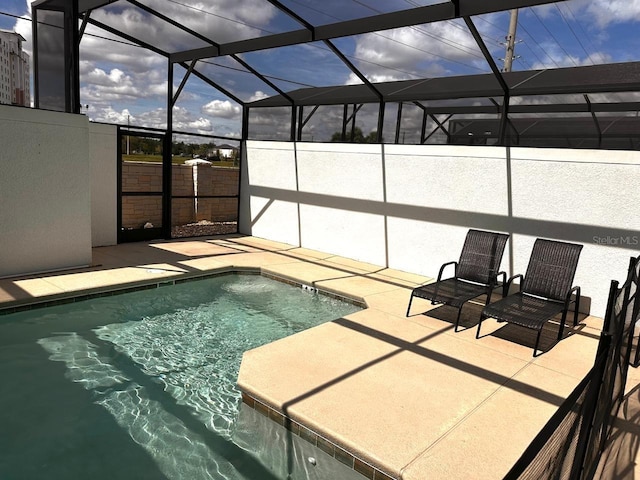 pool with glass enclosure and a patio area