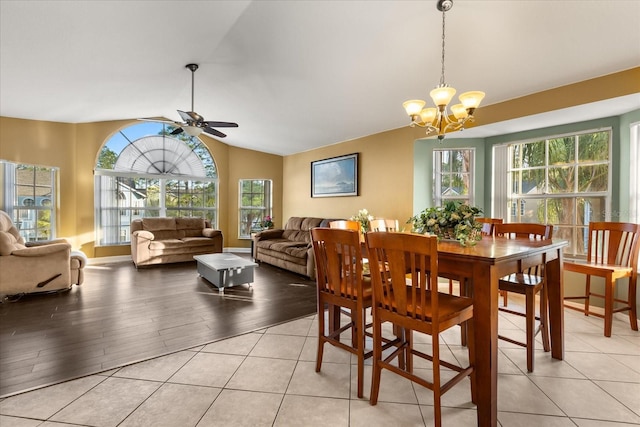 dining room with lofted ceiling, light wood-style flooring, and ceiling fan with notable chandelier