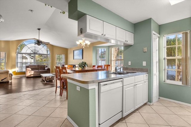 kitchen featuring dishwasher, light tile patterned floors, ceiling fan with notable chandelier, white cabinetry, and a sink