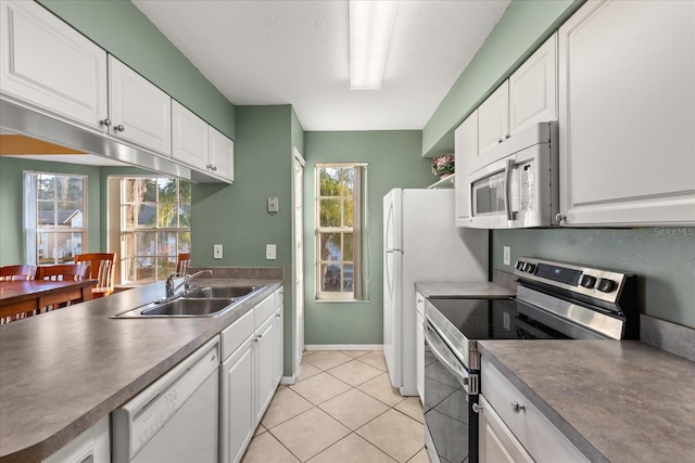 kitchen featuring plenty of natural light, white cabinets, white appliances, and a sink