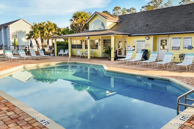 pool featuring a patio, fence, and french doors