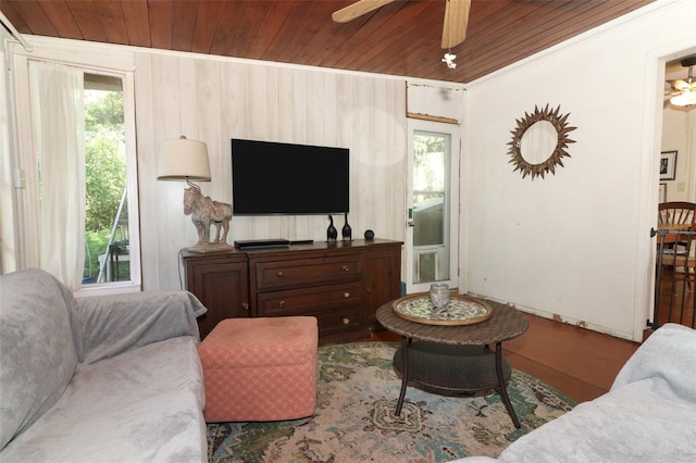 living room with wood ceiling, wood finished floors, ceiling fan, and crown molding