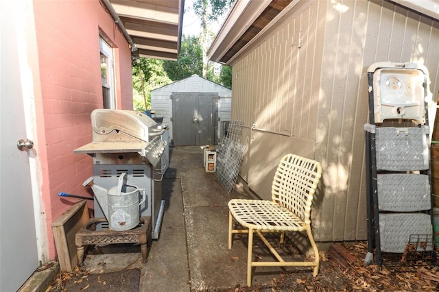 view of side of property featuring a storage unit, concrete block siding, and an outdoor structure