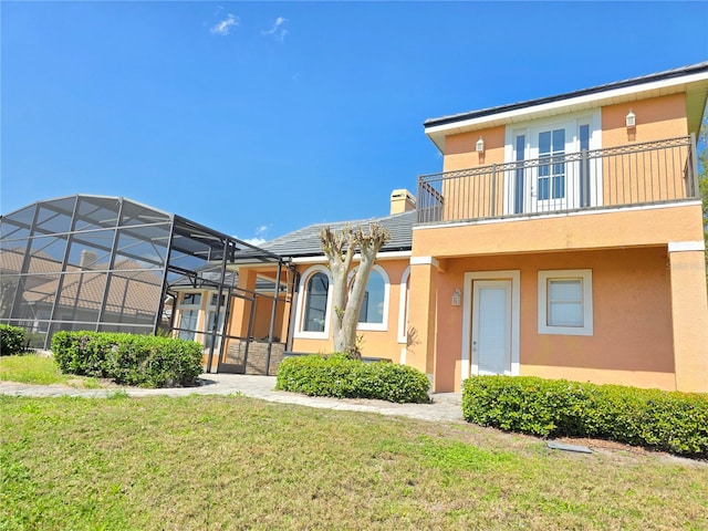 9137 Southern Breeze Dr, Orlando, FL 32836 - back of property featuring a lawn, a chimney, a balcony, and stucco siding