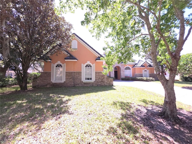 9137 Southern Breeze Dr, Orlando, FL 32836 - view of front of property with a front yard, driveway, stone siding, and stucco siding