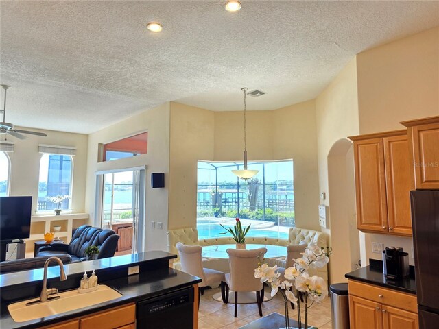9137 Southern Breeze Dr, Orlando, FL 32836 - kitchen with a textured ceiling, a sink, freestanding refrigerator, open floor plan, and black dishwasher