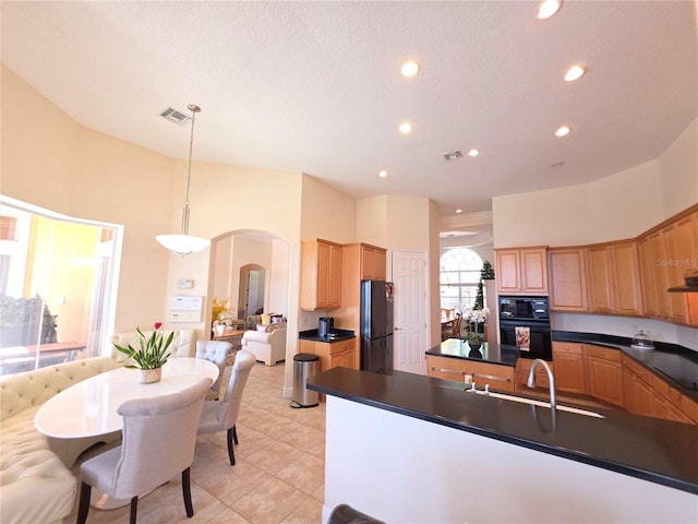 9137 Southern Breeze Dr, Orlando, FL 32836 - kitchen with visible vents, dark countertops, arched walkways, black appliances, and recessed lighting