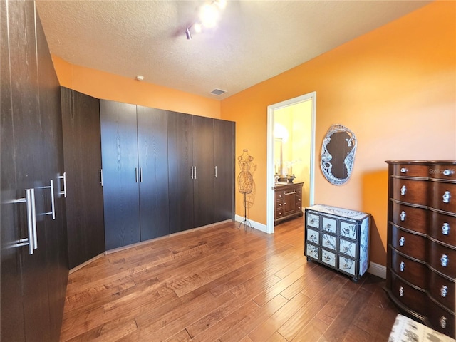 9137 Southern Breeze Dr, Orlando, FL 32836 - bedroom with a closet, visible vents, baseboards, a textured ceiling, and hardwood / wood-style flooring