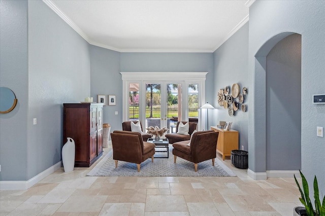 living area with baseboards, arched walkways, ornamental molding, and stone finish floor