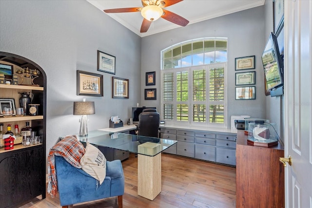 office space featuring ceiling fan, wood finished floors, and crown molding