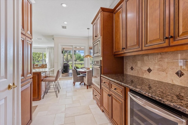 kitchen featuring decorative backsplash, brown cabinetry, beverage cooler, and stainless steel appliances