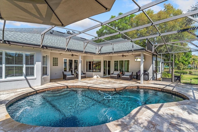 pool with a ceiling fan, grilling area, glass enclosure, outdoor lounge area, and a patio area