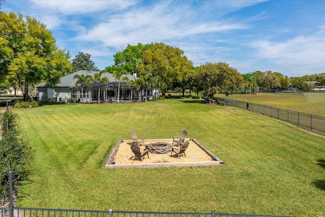 view of yard featuring a rural view, a fire pit, and fence