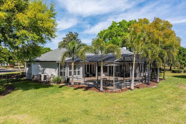 back of property featuring a patio, fence, stucco siding, a lanai, and a lawn