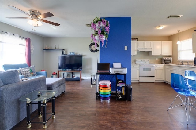 living area featuring a toaster, visible vents, dark wood-style flooring, and ceiling fan