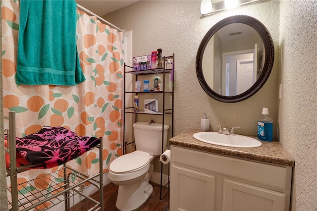 full bath featuring toilet, curtained shower, wood finished floors, vanity, and a textured wall
