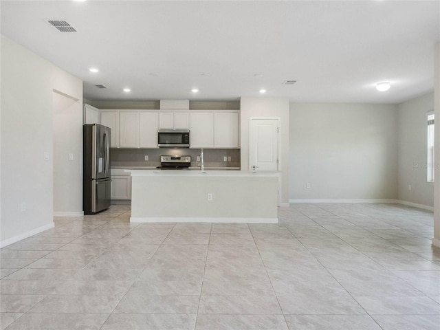 kitchen with baseboards, open floor plan, light countertops, appliances with stainless steel finishes, and white cabinetry