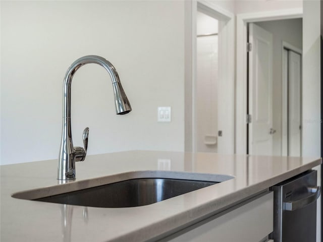 details with stainless steel dishwasher, light countertops, and a sink