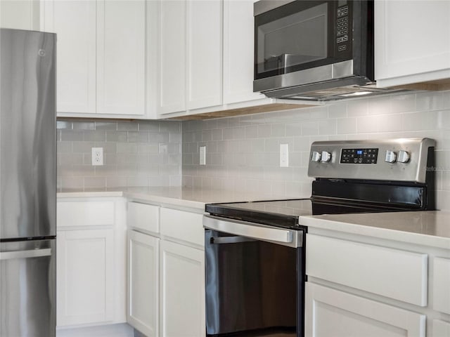 kitchen featuring decorative backsplash, white cabinets, appliances with stainless steel finishes, and light countertops