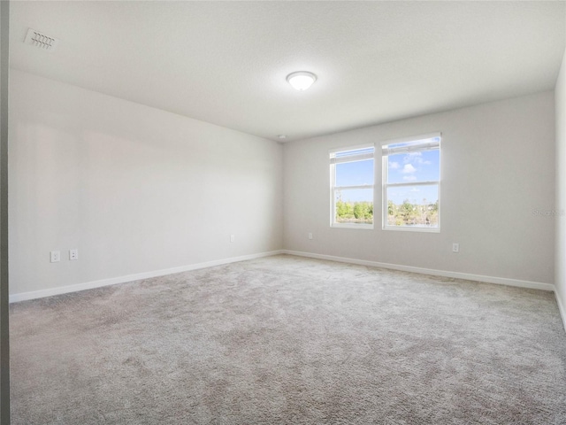 empty room featuring baseboards, visible vents, and carpet floors