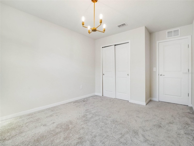 unfurnished bedroom with visible vents, baseboards, a notable chandelier, and carpet flooring