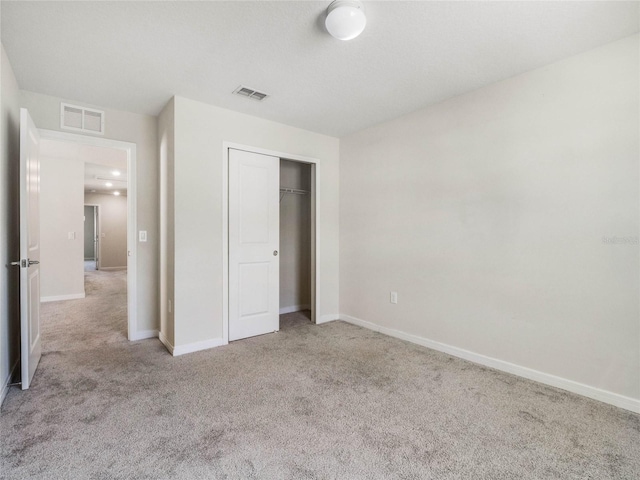 unfurnished bedroom with a closet, visible vents, baseboards, and carpet floors