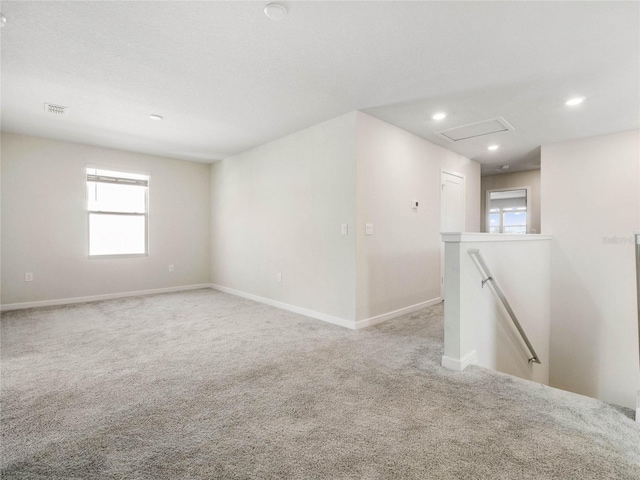 carpeted empty room featuring recessed lighting, visible vents, and baseboards