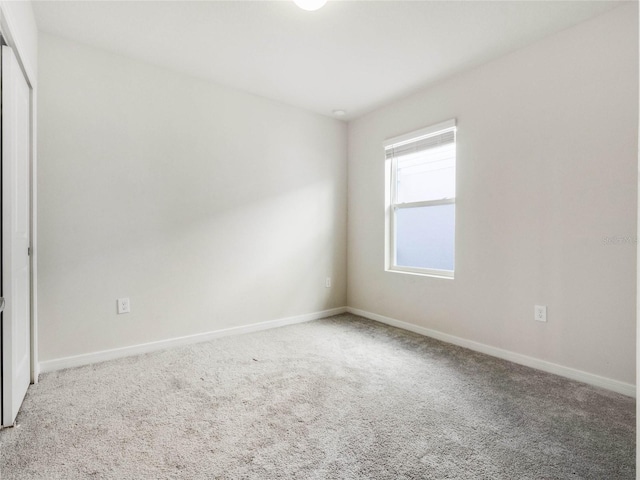 unfurnished room featuring baseboards and carpet