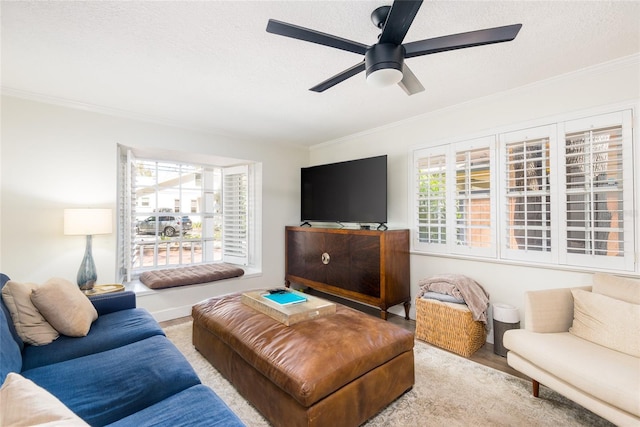 living room with ceiling fan, crown molding, wood finished floors, and a textured ceiling