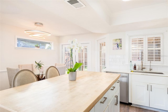 kitchen featuring visible vents, a sink, white cabinetry, light countertops, and dishwasher