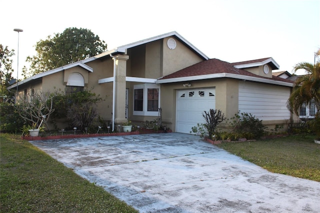 ranch-style house with a front yard, a garage, driveway, and stucco siding