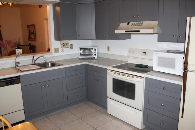 kitchen featuring gray cabinetry, a toaster, range hood, white appliances, and a sink