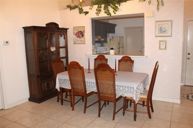 dining area featuring baseboards and light tile patterned flooring